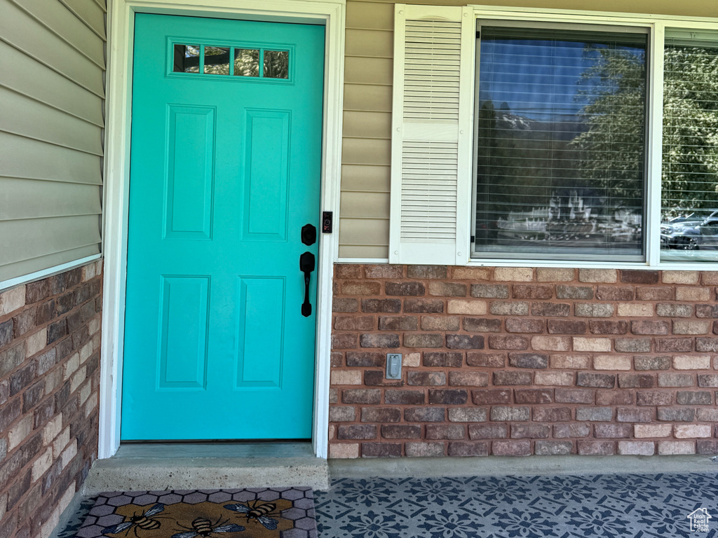 View of exterior entry with brick siding