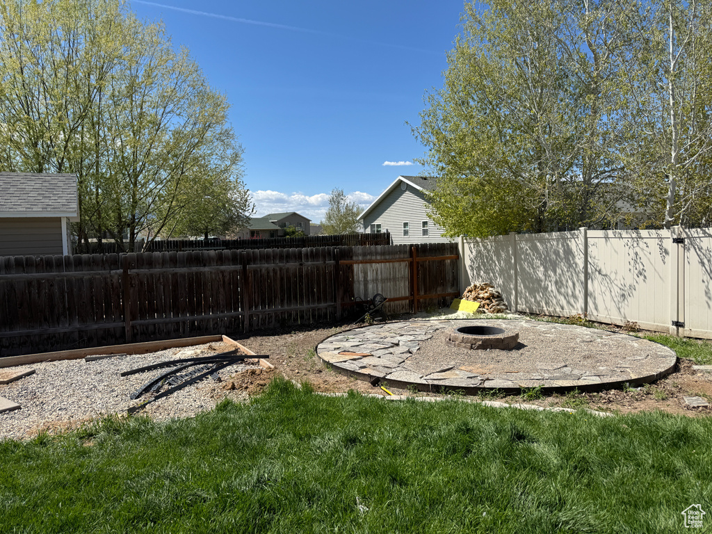 View of yard with a fenced backyard and an outdoor fire pit