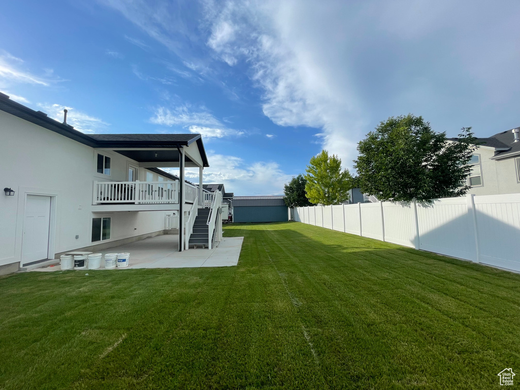 View of yard with stairs, a patio, and a wooden deck