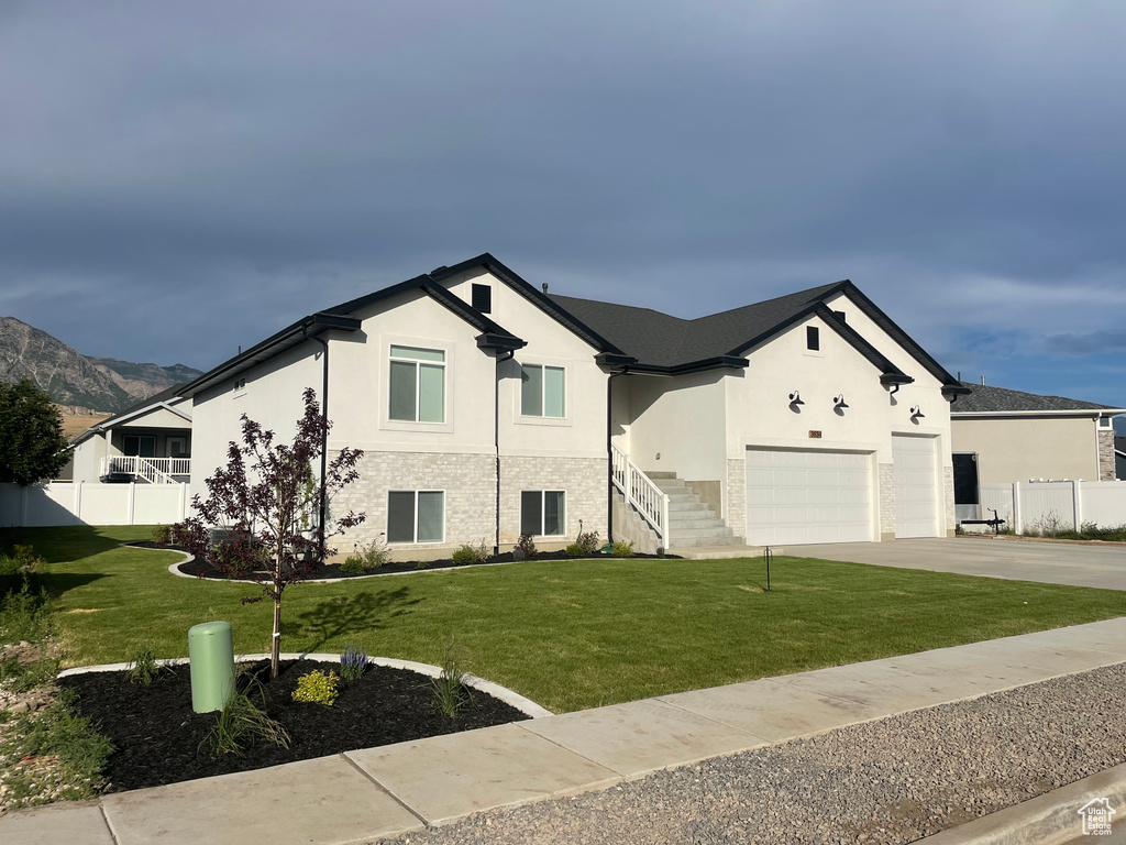 View of front of property featuring stucco siding, driveway, and a garage