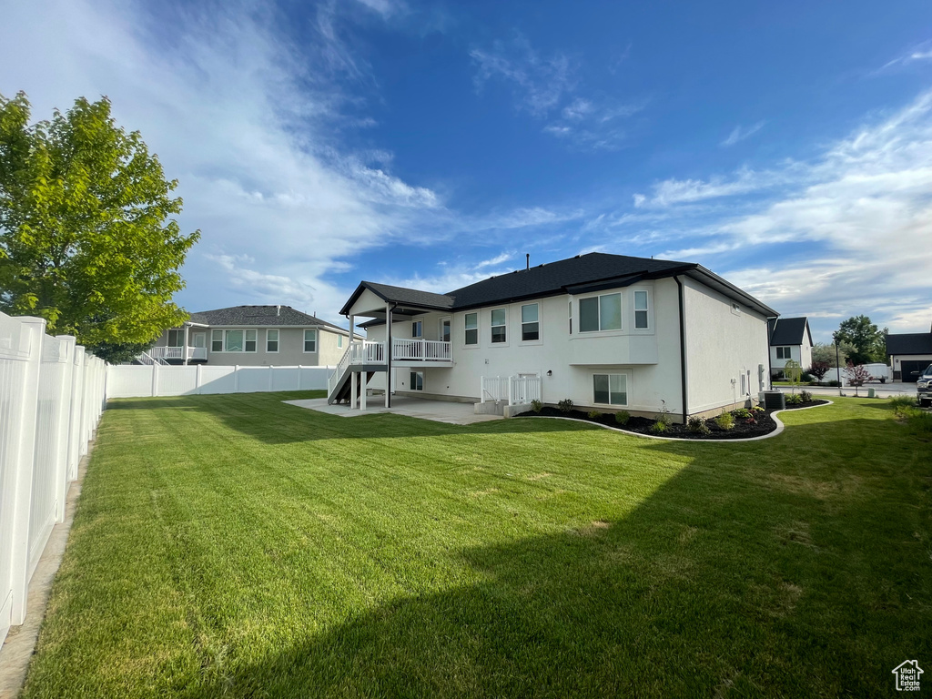 Back of property with central AC unit and a patio
