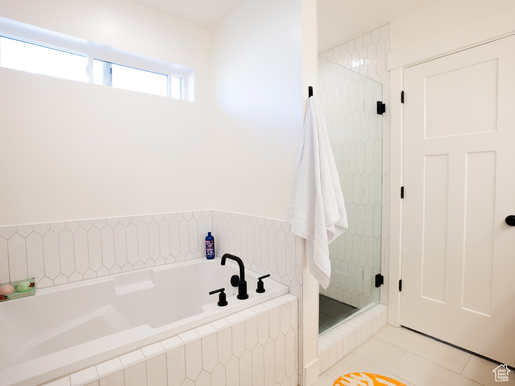 Bathroom with tile patterned flooring, a garden tub, and a stall shower