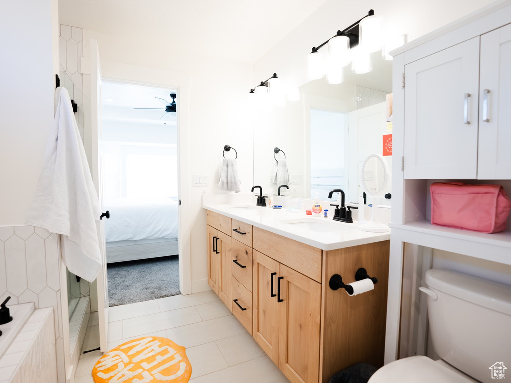 Full bathroom with a sink, tile patterned floors, toilet, and double vanity