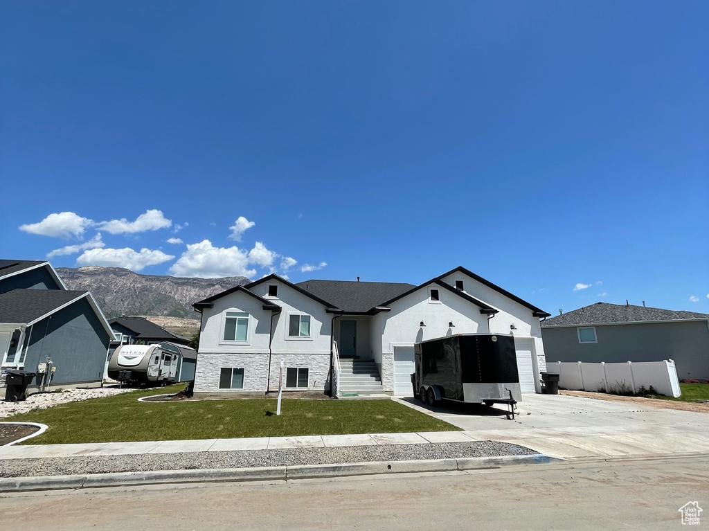 View of front of house with concrete driveway and an attached garage