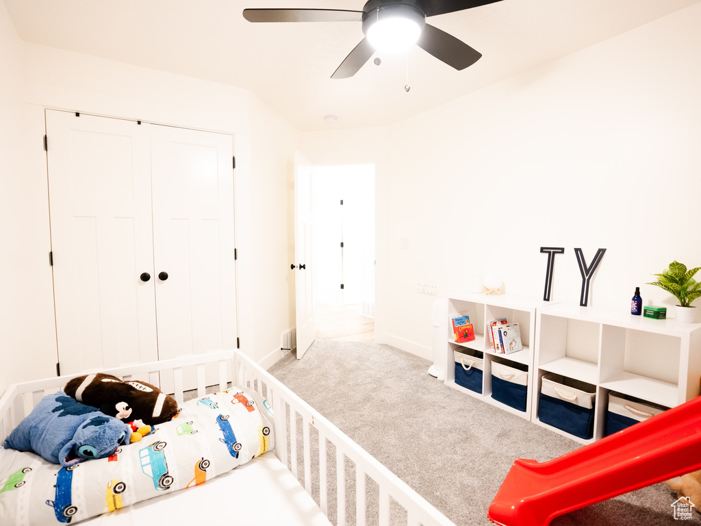 Carpeted bedroom with a closet and ceiling fan
