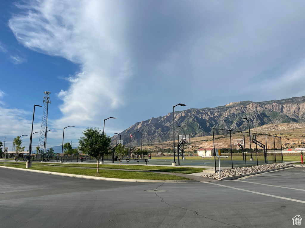 View of asphalt street with street lights, a mountain view, and curbs