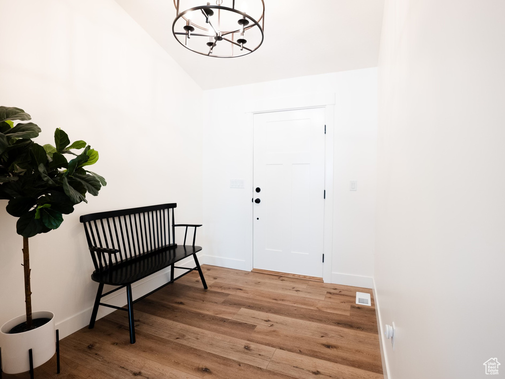 Interior space featuring visible vents, baseboards, high vaulted ceiling, a chandelier, and light wood-style flooring