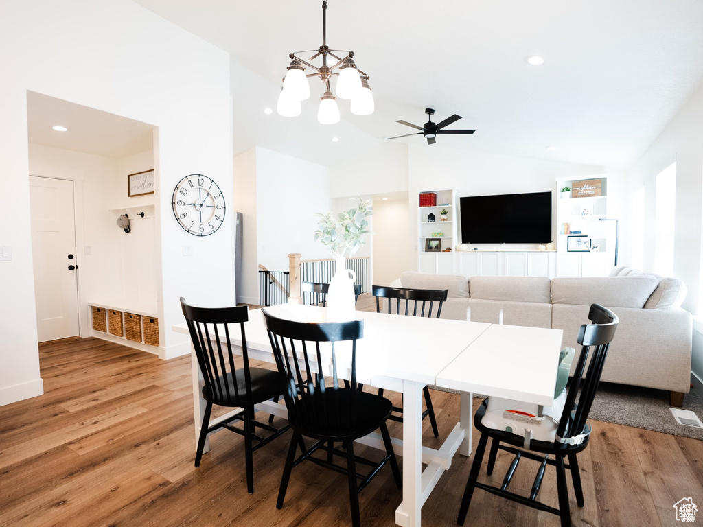 Dining area featuring recessed lighting, vaulted ceiling, ceiling fan with notable chandelier, and light wood-style floors