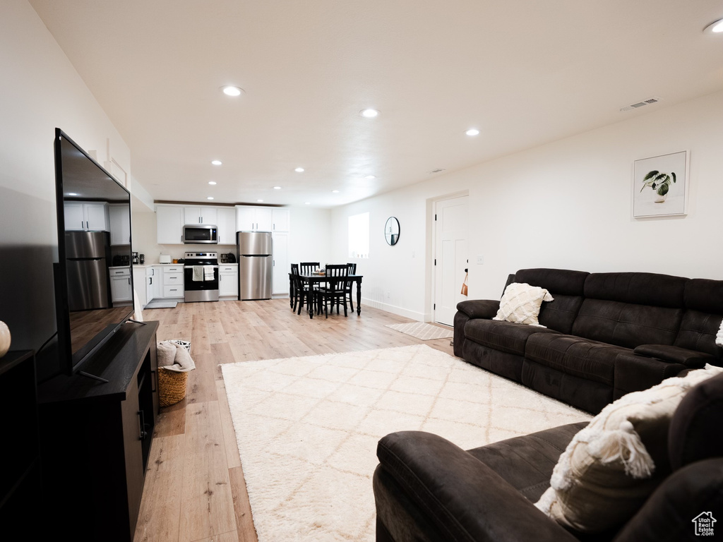 Living area with recessed lighting, light wood-style flooring, and visible vents