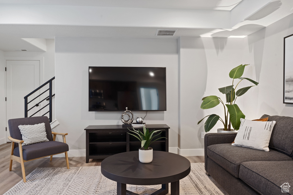 Living area with baseboards, visible vents, and light wood-style flooring