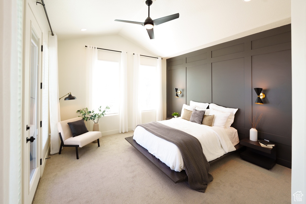 Bedroom with ceiling fan, vaulted ceiling, and light carpet