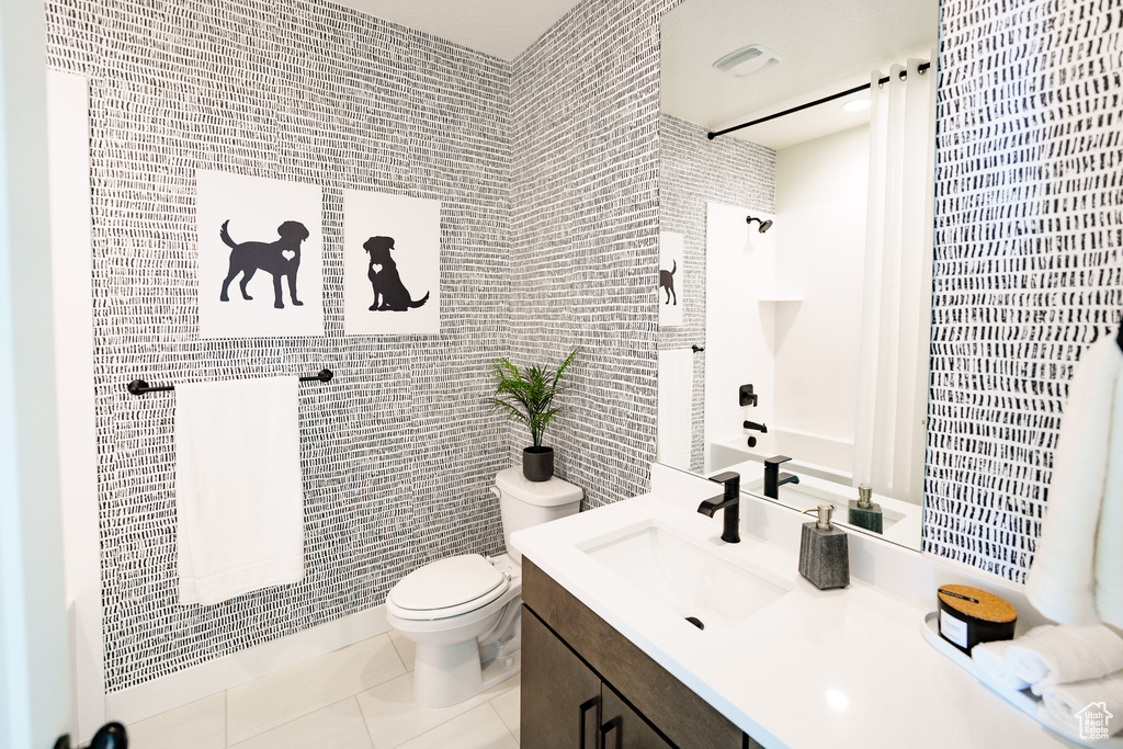 Full bath featuring tile patterned floors, vanity, toilet, and tile walls