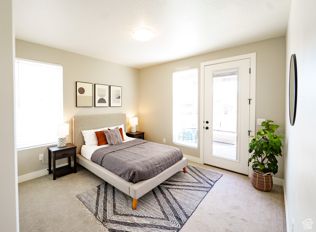Carpeted bedroom with french doors, access to outside, and baseboards