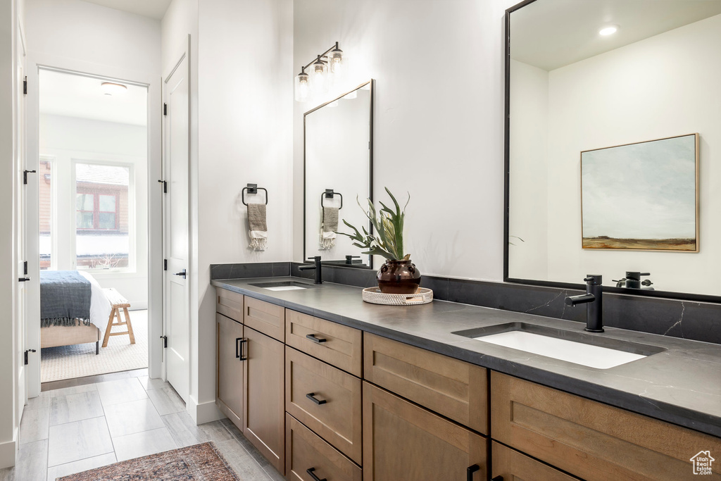 Full bathroom featuring a sink, recessed lighting, double vanity, and connected bathroom