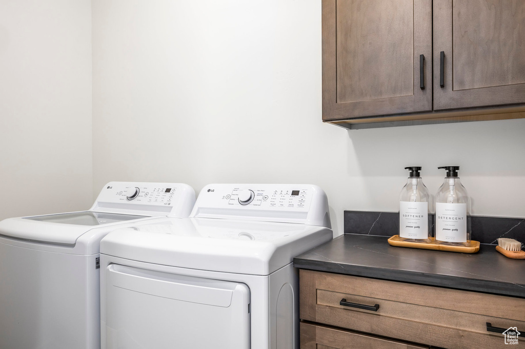 Clothes washing area featuring cabinet space and washing machine and dryer