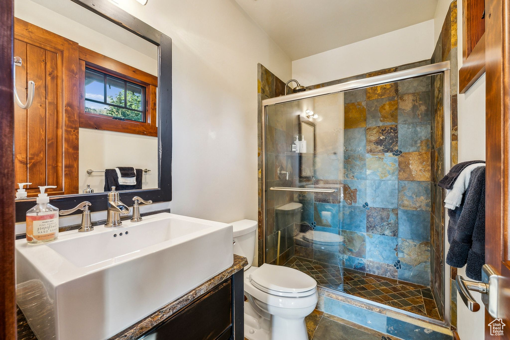 Bathroom featuring toilet, a shower stall, and vanity