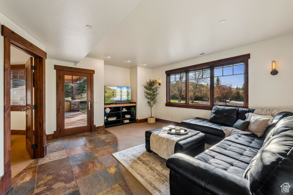 Living area with baseboards and stone tile floors