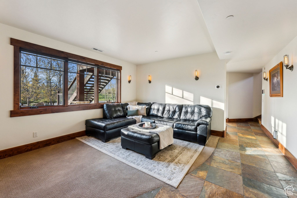 Living room with stone tile floors, baseboards, and visible vents