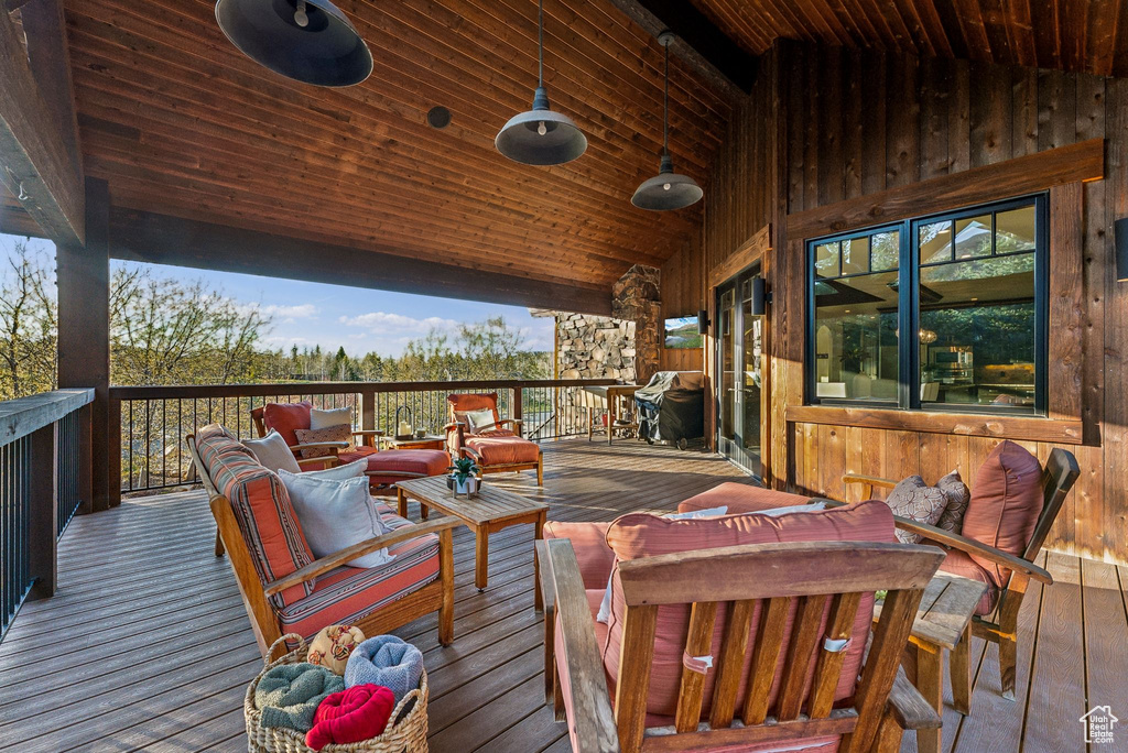 Wooden deck with area for grilling and an outdoor living space