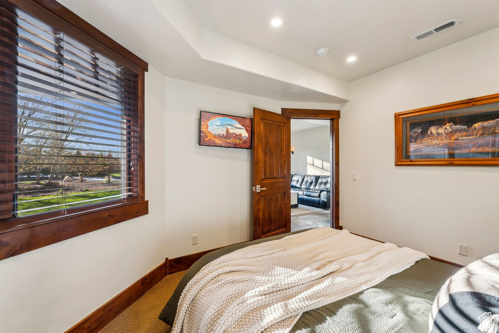 Carpeted bedroom with baseboards, recessed lighting, and visible vents