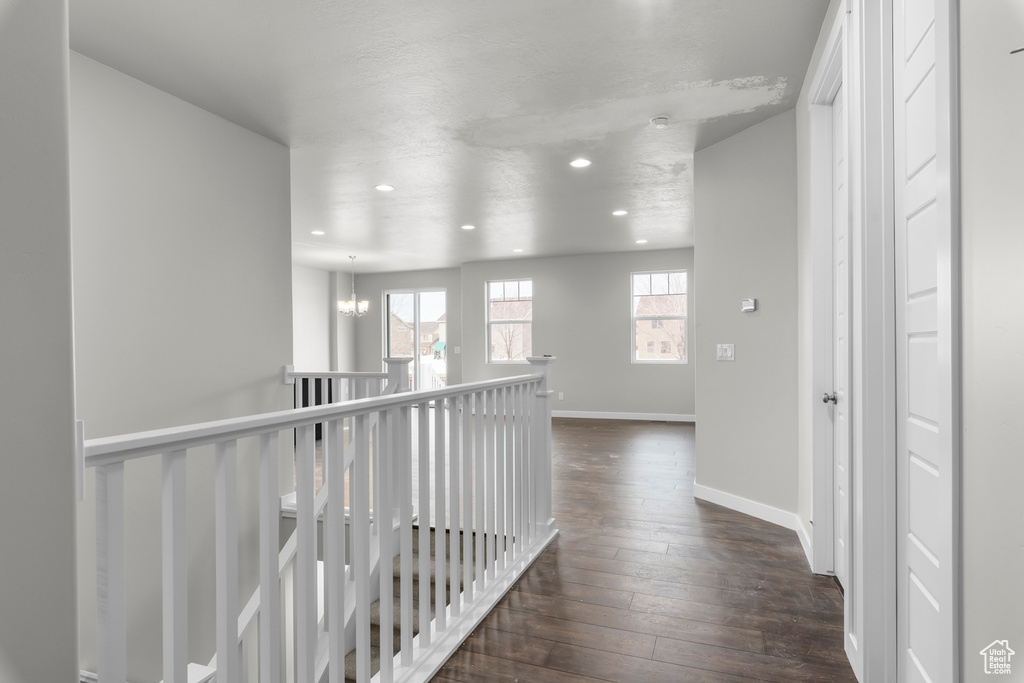 Hallway with baseboards, dark wood-style flooring, recessed lighting, and an upstairs landing