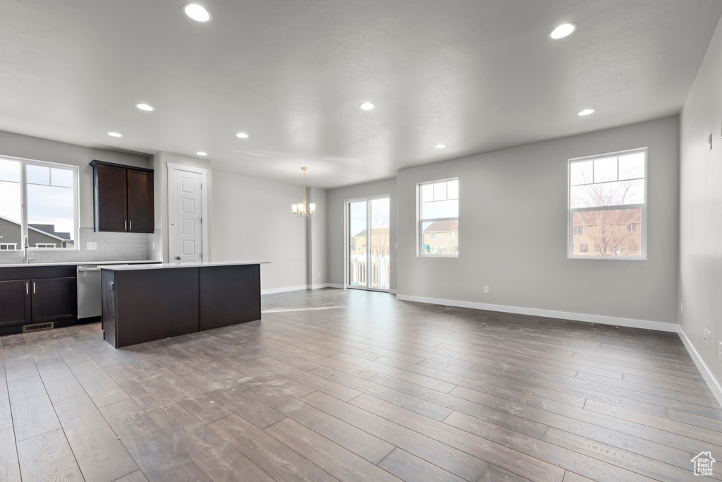 Kitchen with a chandelier, a center island, light countertops, open floor plan, and recessed lighting