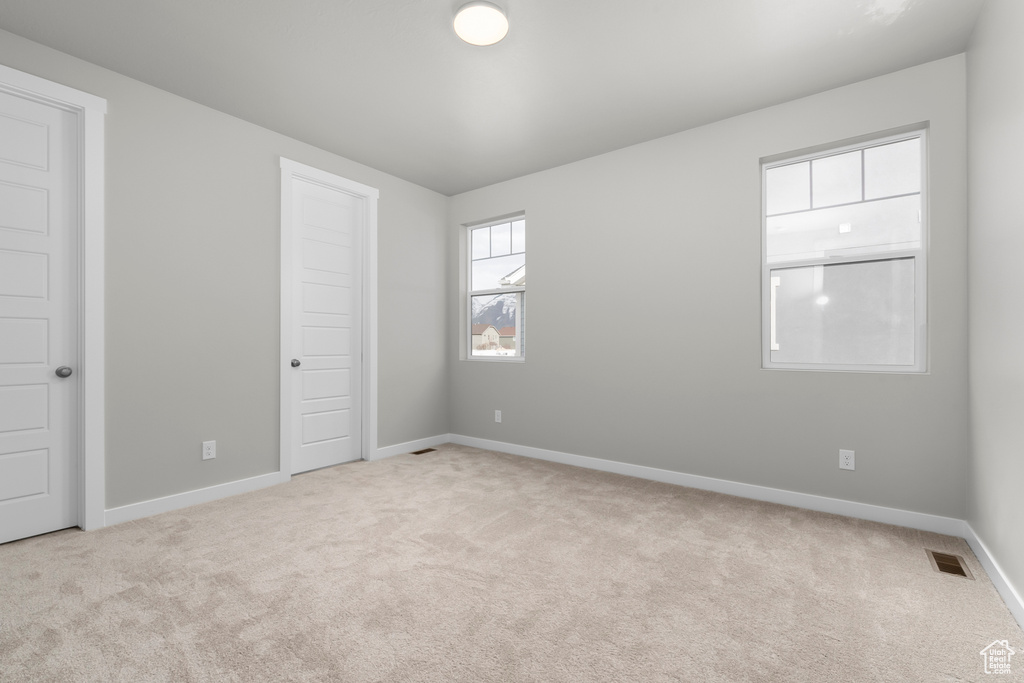 Unfurnished bedroom featuring visible vents, carpet, and baseboards