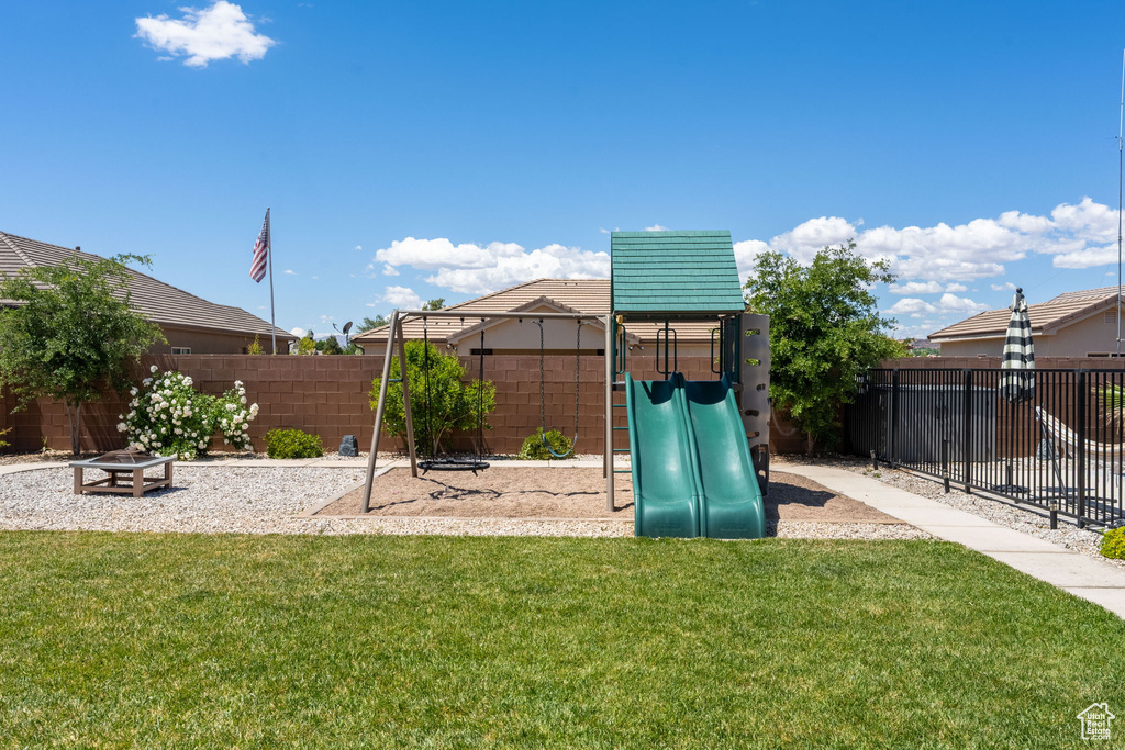 View of jungle gym with a fenced backyard and a yard