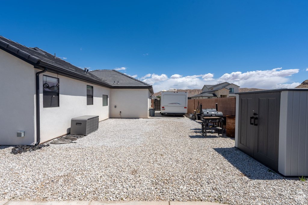 View of yard with a patio, fence, an outbuilding, and a shed