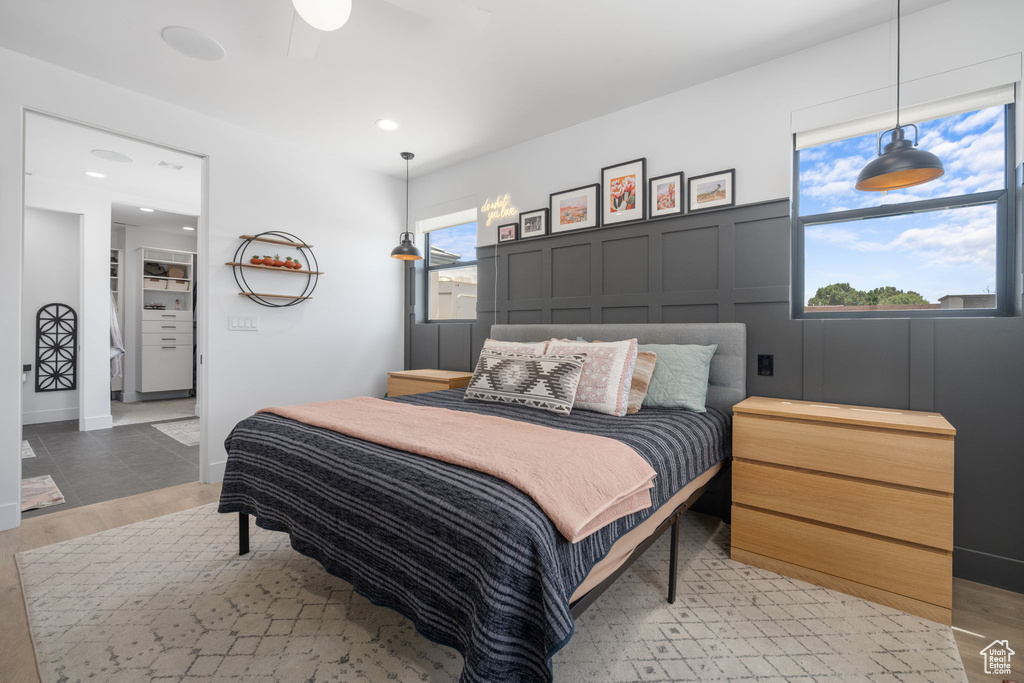 Bedroom featuring recessed lighting, light wood finished floors, and a decorative wall