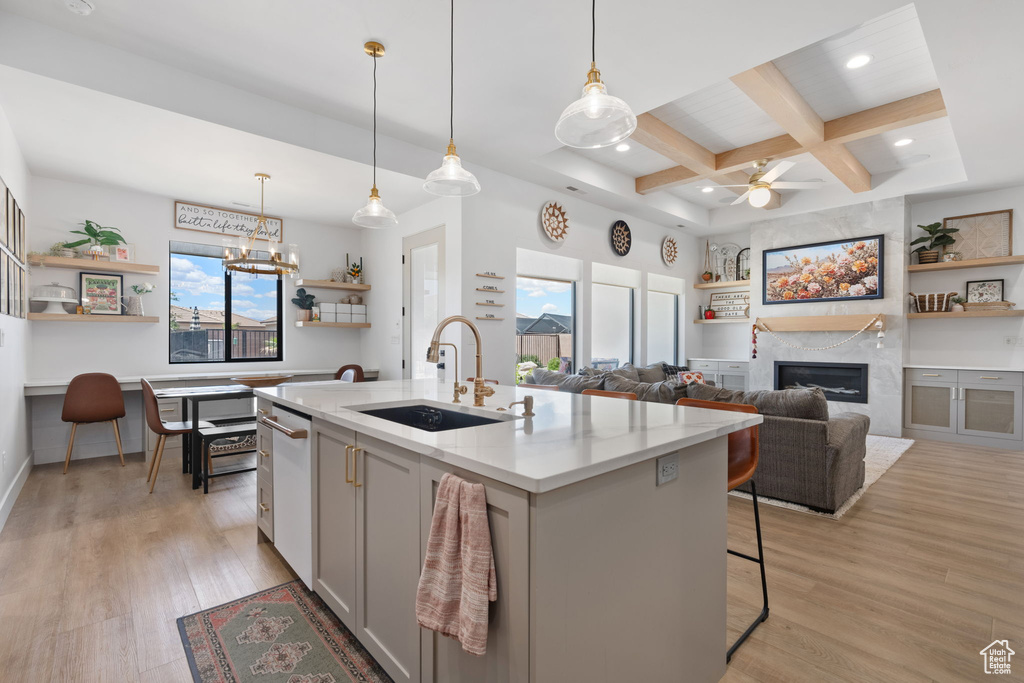 Kitchen featuring open shelves, a sink, a large fireplace, a wealth of natural light, and coffered ceiling