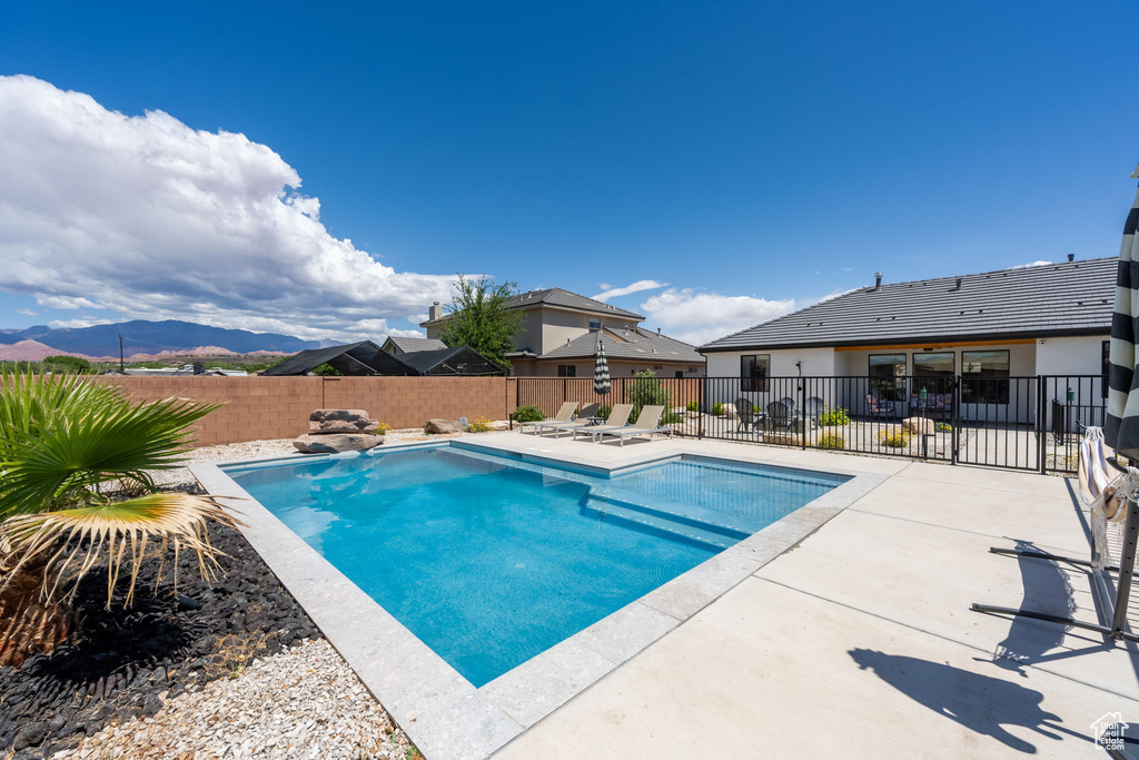 View of pool featuring a fenced in pool, a fenced backyard, a patio area, and a mountain view