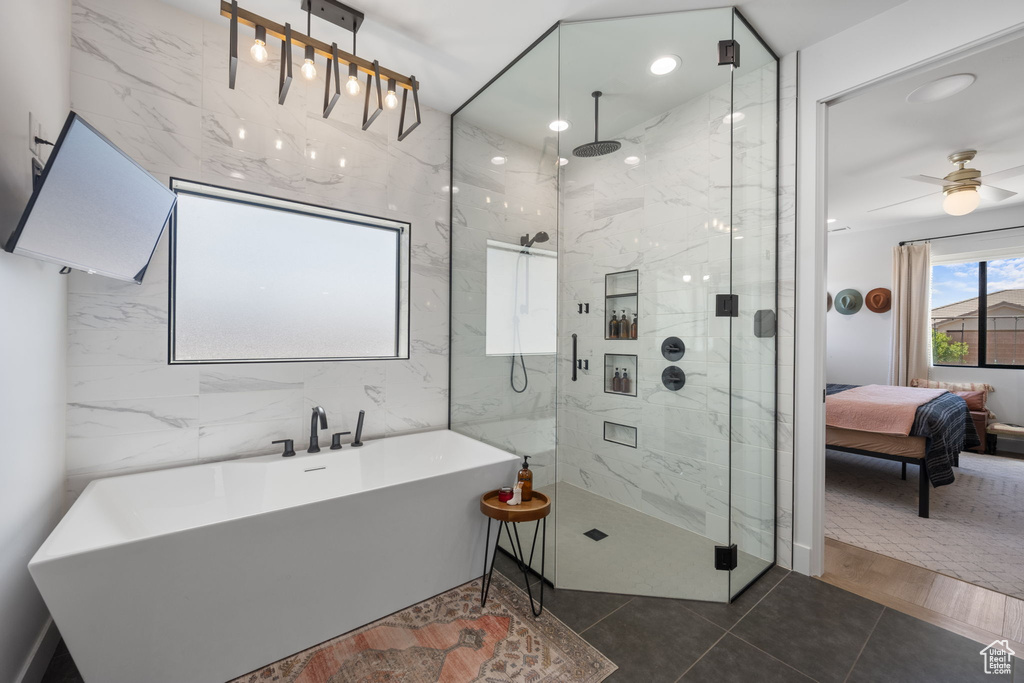 Full bathroom featuring tile patterned flooring, a freestanding tub, ceiling fan, a marble finish shower, and ensuite bath