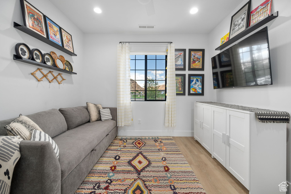 Living area with visible vents, recessed lighting, light wood finished floors, and baseboards