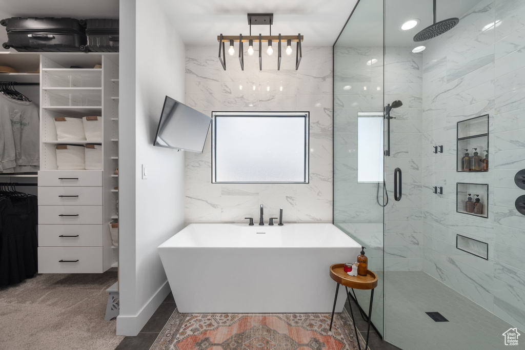 Full bathroom with a freestanding tub and a marble finish shower