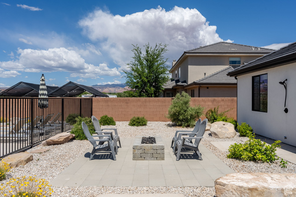 View of patio with a fenced backyard and a fire pit