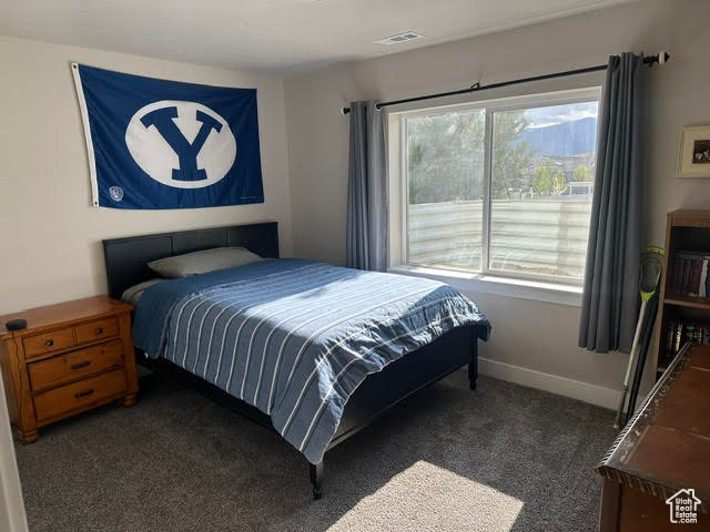 Bedroom with baseboards, visible vents, and carpet