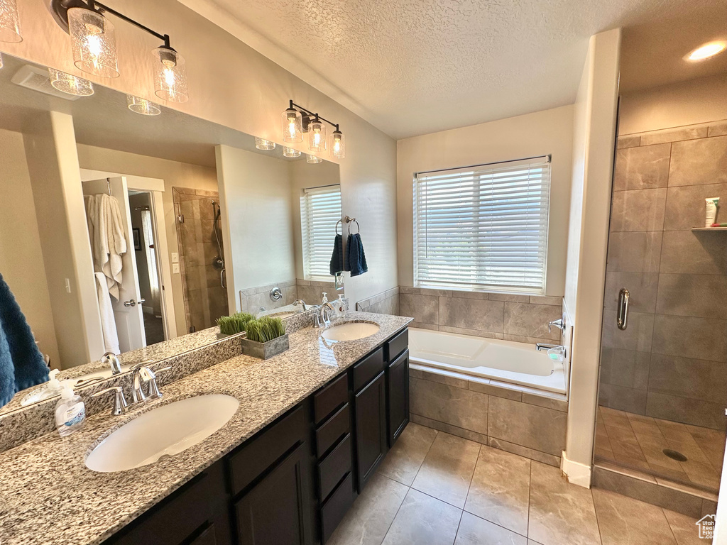 Bathroom with a healthy amount of sunlight, a sink, a bath, and a stall shower