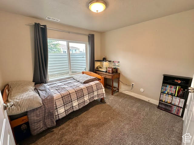 Bedroom featuring baseboards, visible vents, and carpet
