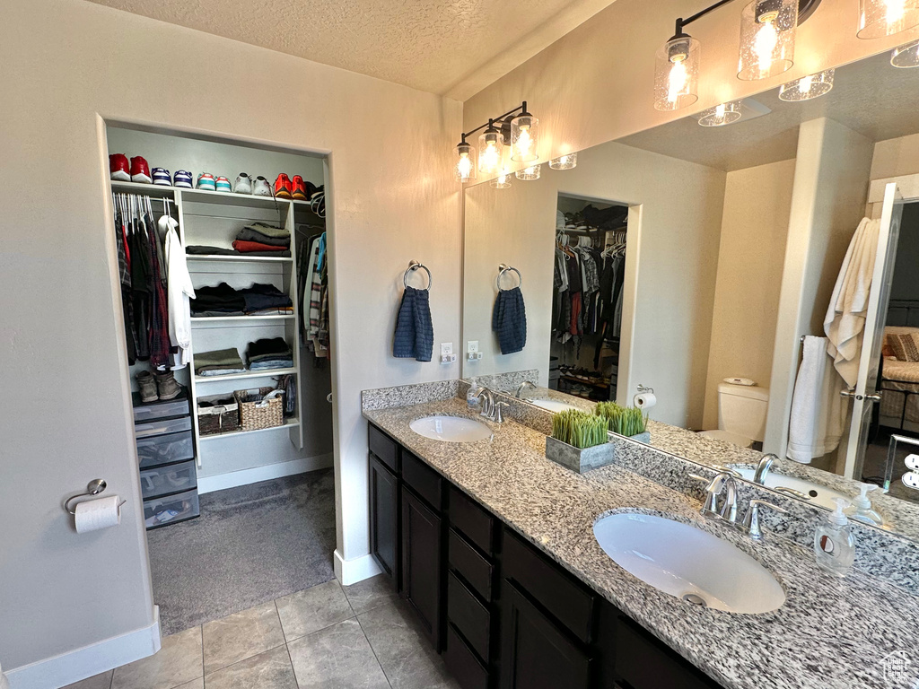 Bathroom with a sink, toilet, and a textured ceiling