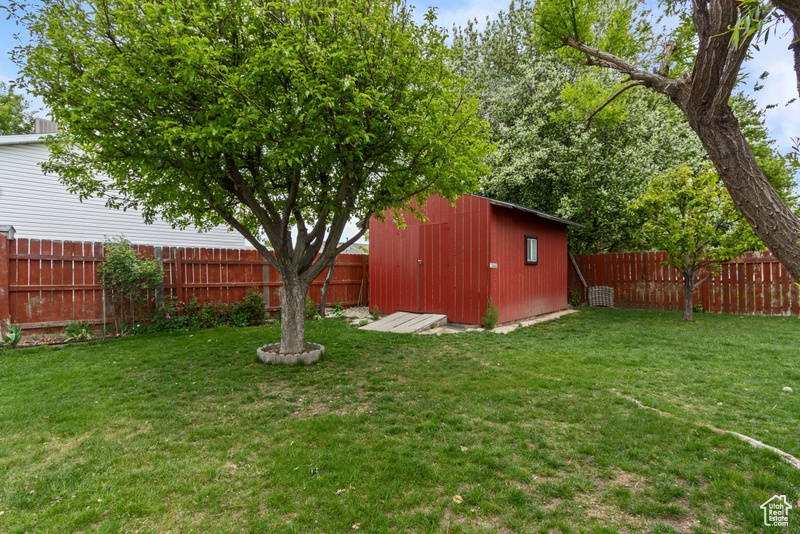 View of yard featuring a fenced backyard, an outbuilding, and a storage shed