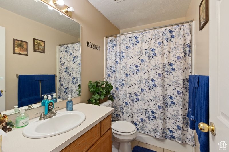 Bathroom with vanity, tile patterned floors, and toilet