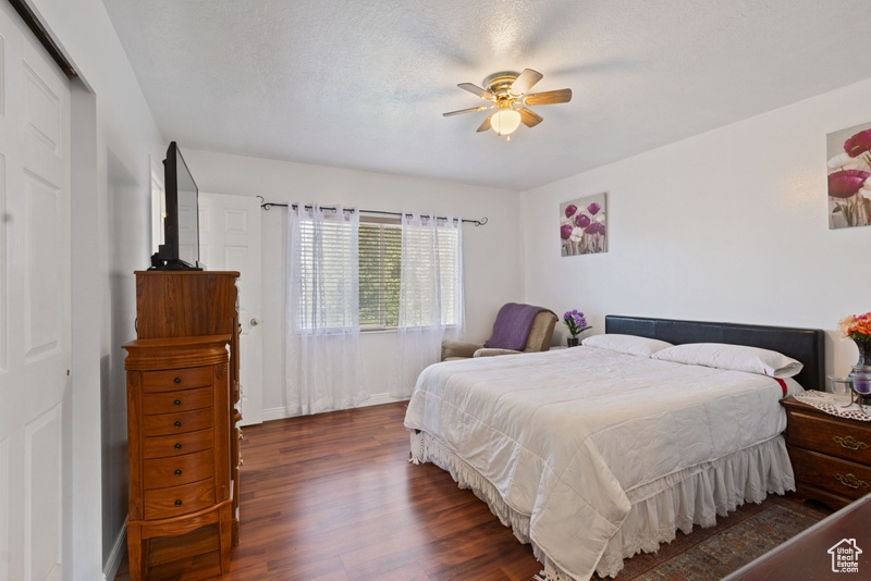 Bedroom with baseboards, ceiling fan, and dark wood-style floors
