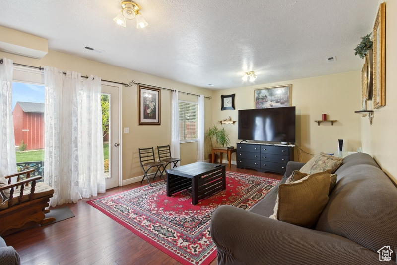 Living area with baseboards, visible vents, and wood finished floors
