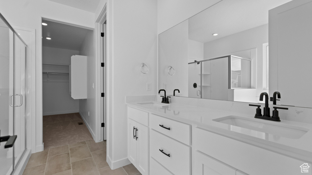 Bathroom with a sink, a stall shower, and double vanity