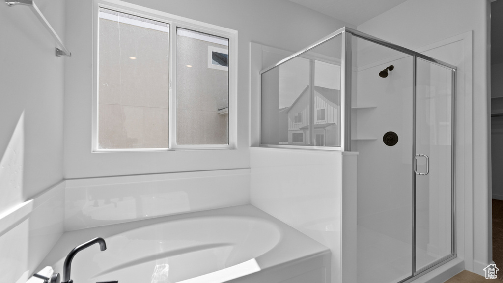 Bathroom featuring a bath and a stall shower
