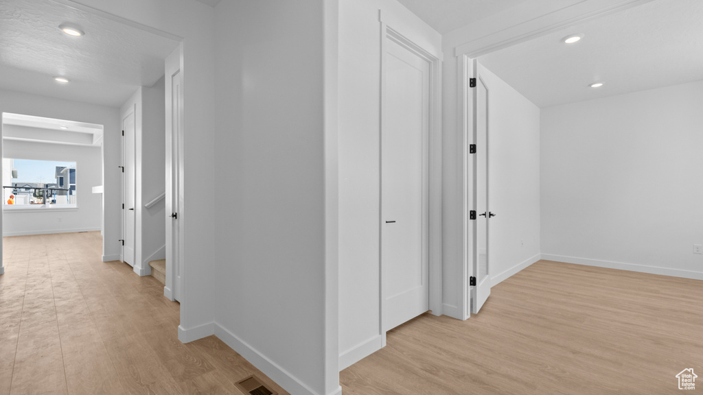 Hall with recessed lighting, baseboards, visible vents, and light wood-style flooring