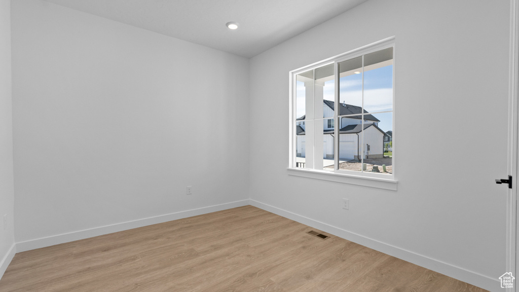 Unfurnished room featuring visible vents, baseboards, a wealth of natural light, and light wood-type flooring