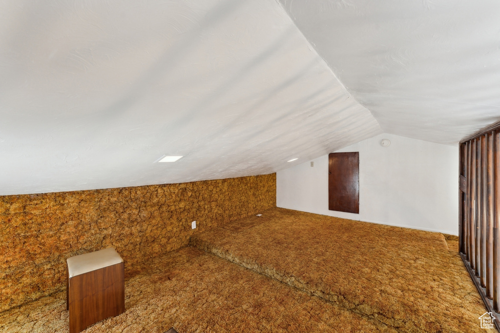 Additional living space with carpet and vaulted ceiling
