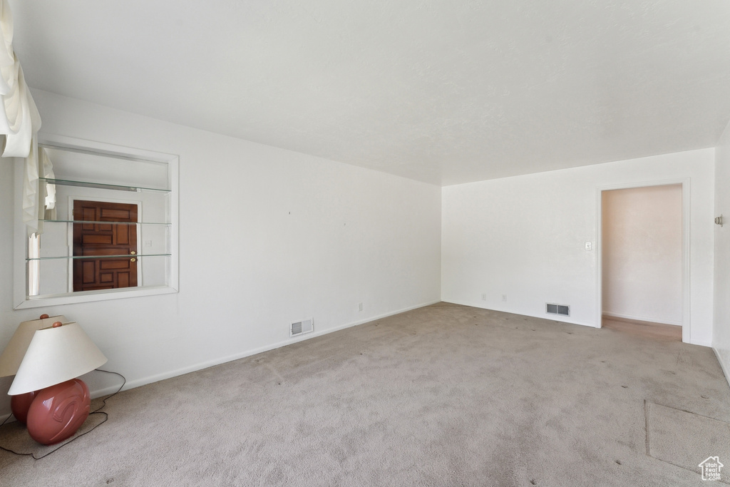 Carpeted spare room with baseboards and visible vents